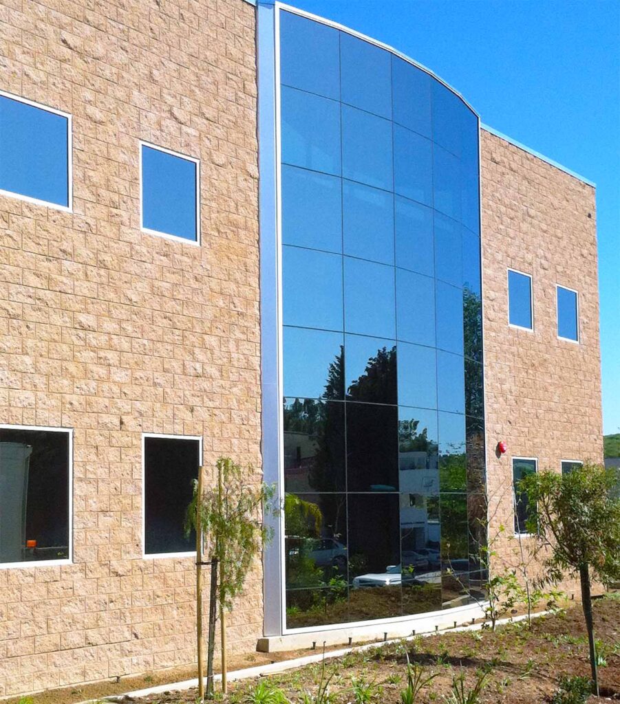 A rock building with an eye catching frameless multi glass panel center.