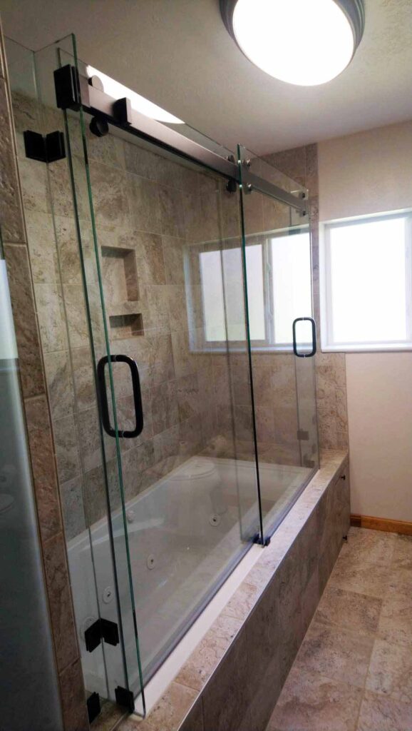 Stone tiles and frameless glass shower.