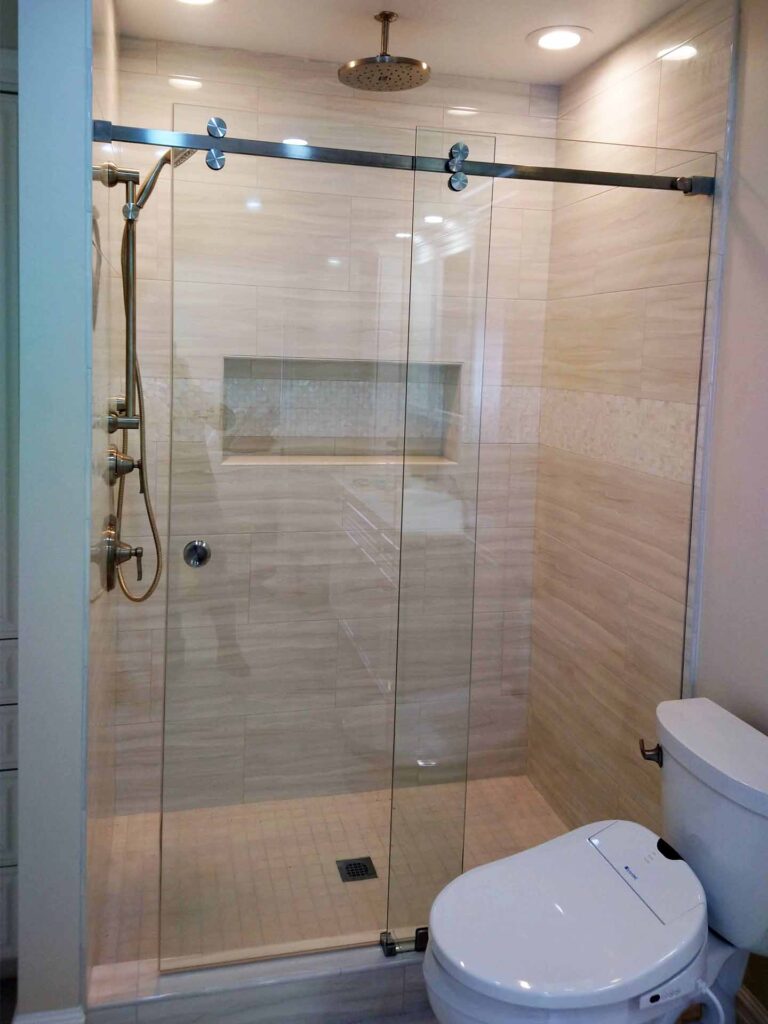 Compact luxory bathroom with sliding frameless glass shower doors.
