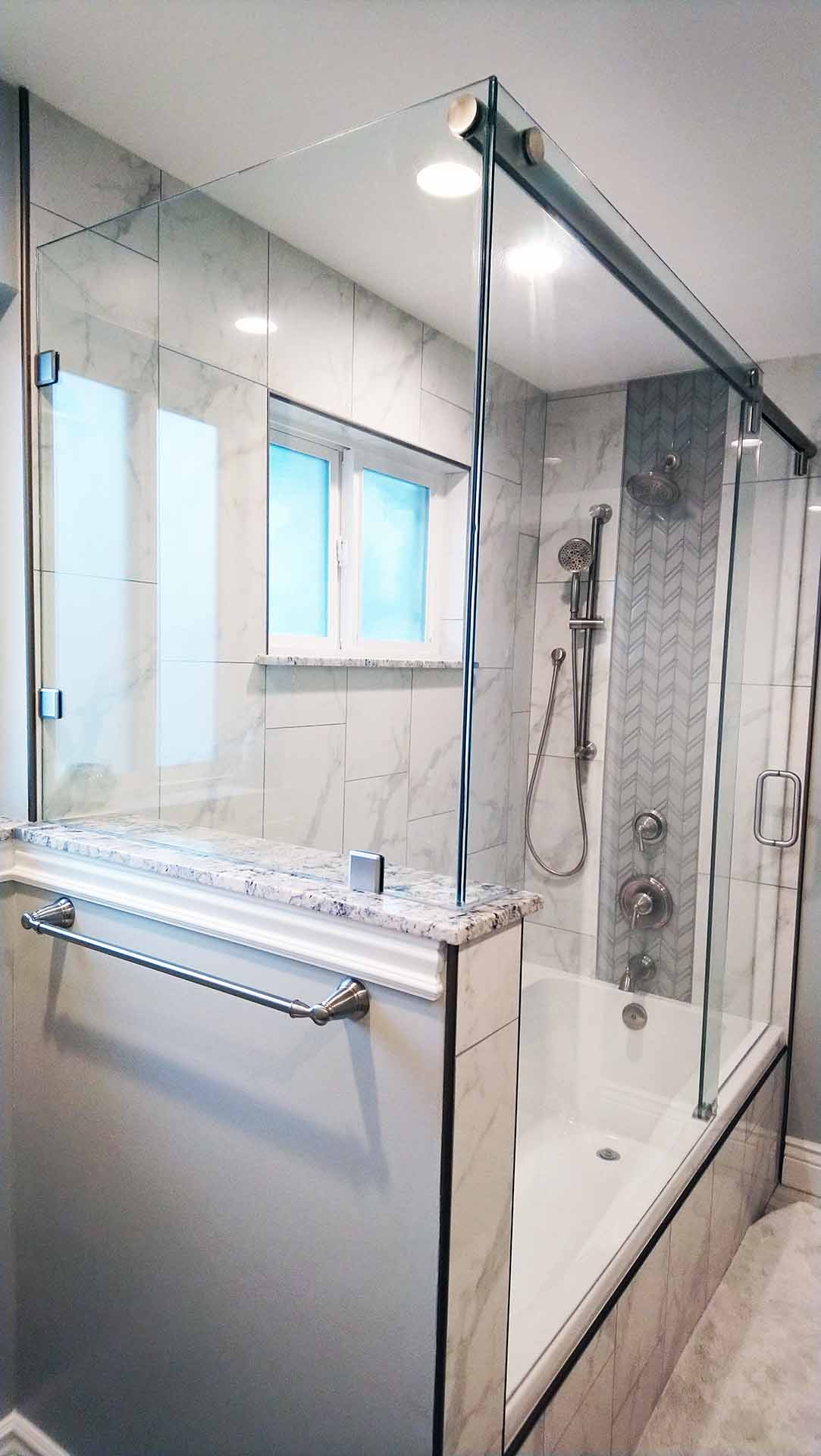 Shower-bathtube enclosed with frameless glass with sliding doors.