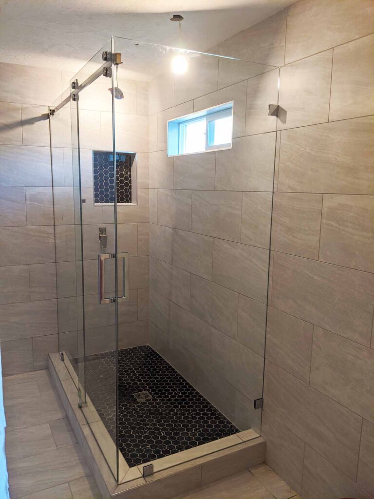 Luxory and simple looking bathroom with sliding glass shower doors.